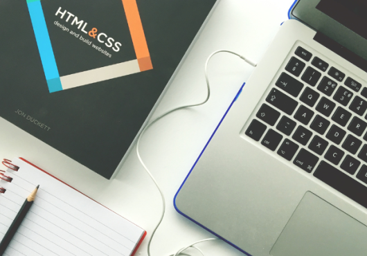 Top view of laptop with HTML design book